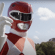 The Red Ranger from Mighty Mophpin Power Rangers standing in a powerful pose, wearing his signature red spandex suit with white diamond patterns, white gloves, and a helmet with a T-Rex design.