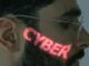 A close-up of a man's face illuminated by glowing green cyber text reflecting across his skin, symbolizing cybersecurity and digital interfaces.