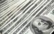 Stack of 100 US dollar banknotes arranged neatly, representing the $100 habit.