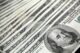 Stack of 100 US dollar banknotes arranged neatly, representing the $100 habit.