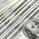 Stack of 100 US dollar banknotes arranged neatly, representing the $100 habit.